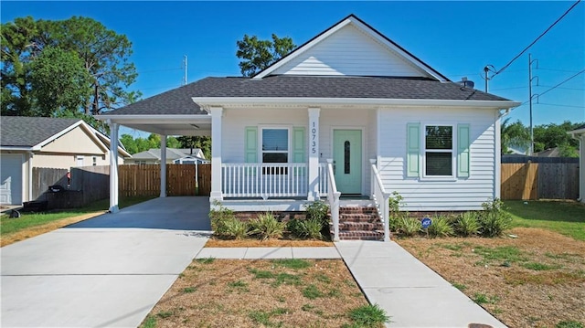 10735 Vienna St, New Orleans, LA 70126 - bungalow-style house with concrete driveway, a carport, roof with shingles, a porch, and fence