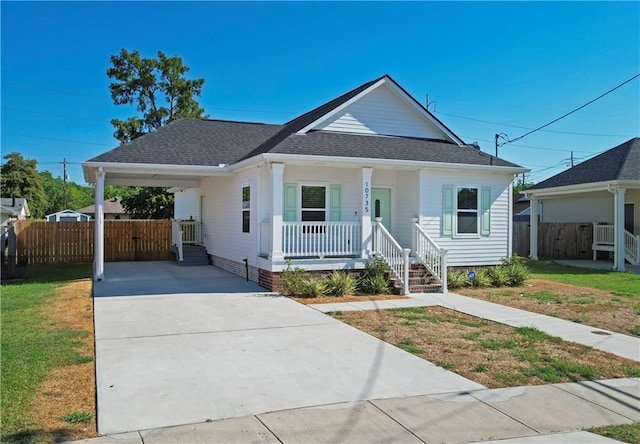 10735 Vienna St, New Orleans, LA 70126 - bungalow-style home featuring a carport, covered porch, fence, and concrete driveway