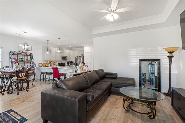 10735 Vienna St, New Orleans, LA 70126 - living area with a raised ceiling, light wood finished floors, ceiling fan, and ornamental molding