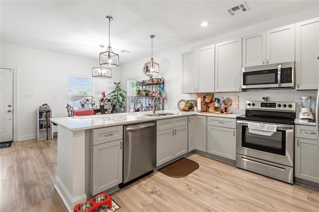 10735 Vienna St, New Orleans, LA 70126 - kitchen with visible vents, a sink, appliances with stainless steel finishes, a peninsula, and gray cabinetry