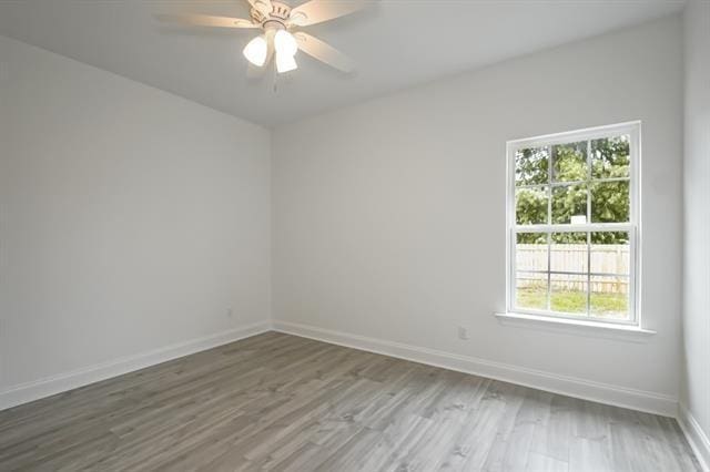 10735 Vienna St, New Orleans, LA 70126 - spare room featuring wood finished floors, ceiling fan, baseboards, and plenty of natural light
