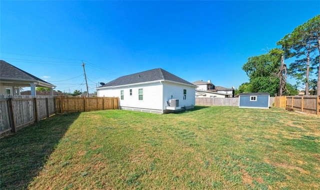 10735 Vienna St, New Orleans, LA 70126 - back of house with central air condition unit, a yard, a fenced backyard, an outdoor structure, and a storage unit