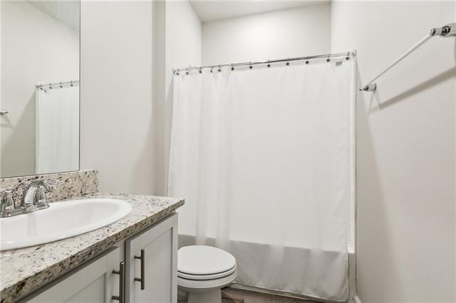 full bathroom with vanity, shower / bathtub combination with curtain, and toilet