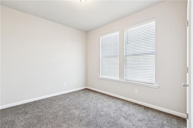 carpeted empty room featuring baseboards
