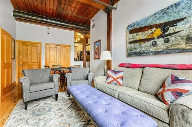living room featuring wood ceiling, wood finished floors, and visible vents