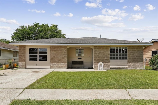 view of front of house featuring a front yard, fence, and brick siding