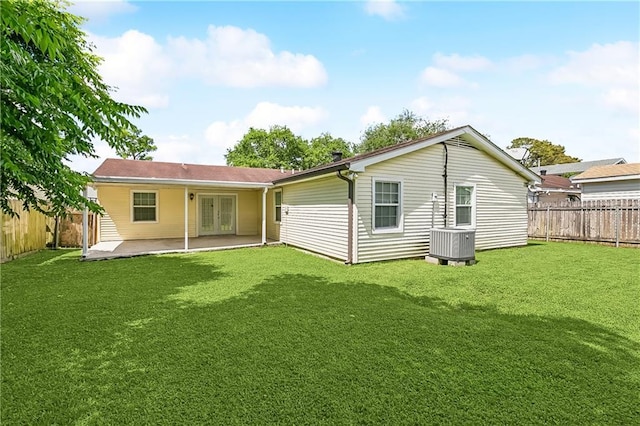 back of house with a yard, french doors, a fenced backyard, and a patio area