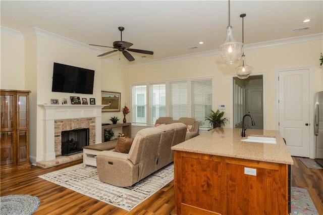living room with dark wood finished floors, visible vents, crown molding, and ceiling fan