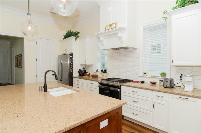 kitchen featuring hanging light fixtures, a sink, white cabinets, and stainless steel appliances