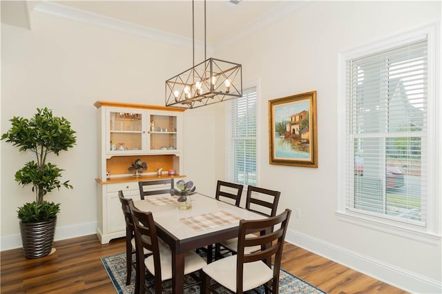 dining area with baseboards, an inviting chandelier, crown molding, and dark wood finished floors