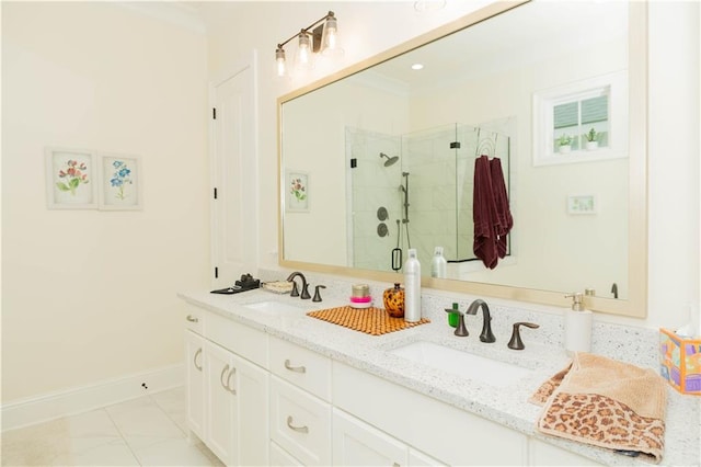 bathroom with a shower stall, double vanity, baseboards, and a sink