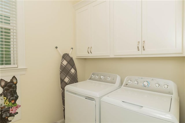 washroom with washer and dryer, baseboards, and cabinet space