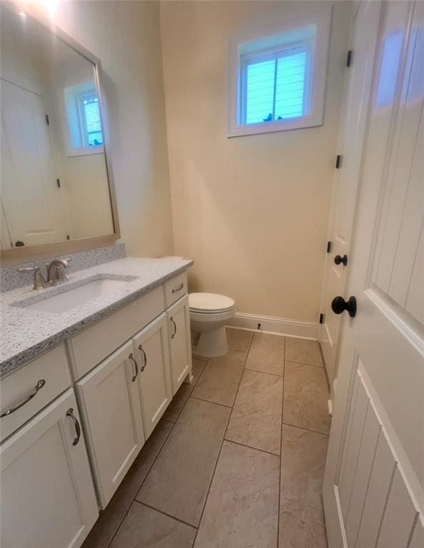 bathroom featuring tile patterned floors, vanity, toilet, and a healthy amount of sunlight