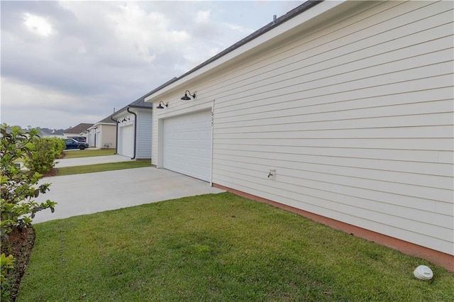 view of side of property featuring a garage, a yard, and driveway