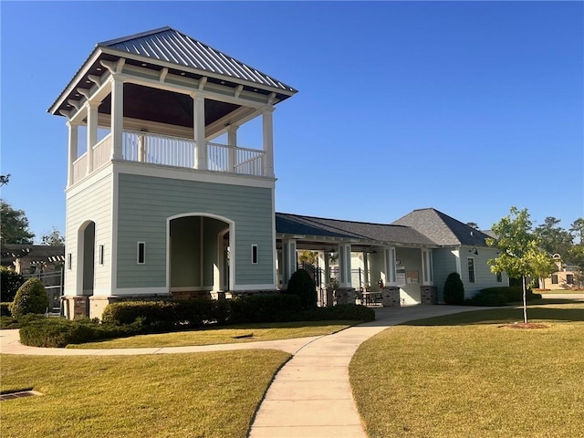 view of front of house with a balcony and a front lawn
