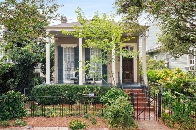 doorway to property with covered porch and fence