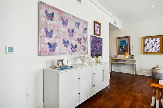 corridor featuring crown molding, visible vents, baseboards, and dark wood-style floors
