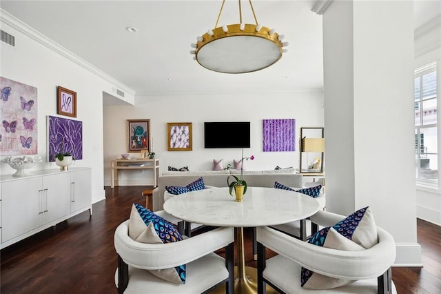 dining area featuring visible vents, ornamental molding, wood finished floors, and a healthy amount of sunlight