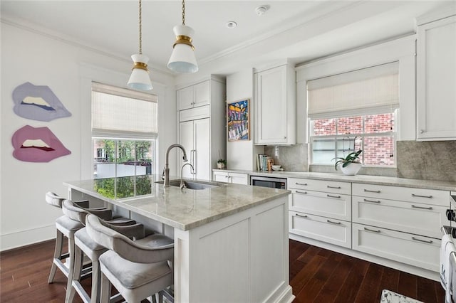 kitchen featuring white cabinetry, a center island with sink, and dark wood finished floors