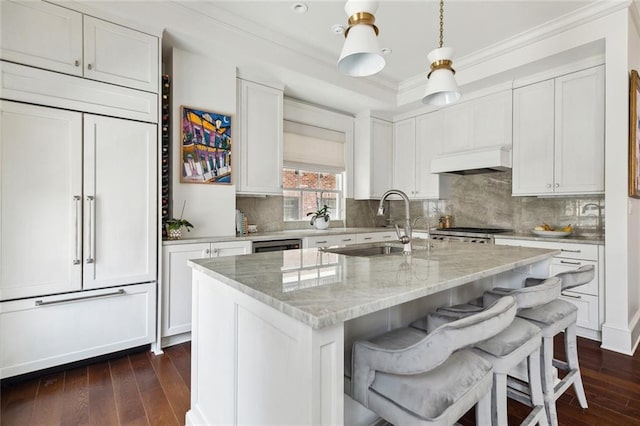 kitchen featuring custom exhaust hood, dark wood-style flooring, crown molding, and paneled built in refrigerator