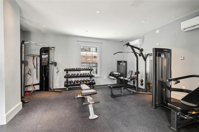 workout area featuring recessed lighting, a wall mounted AC, and baseboards