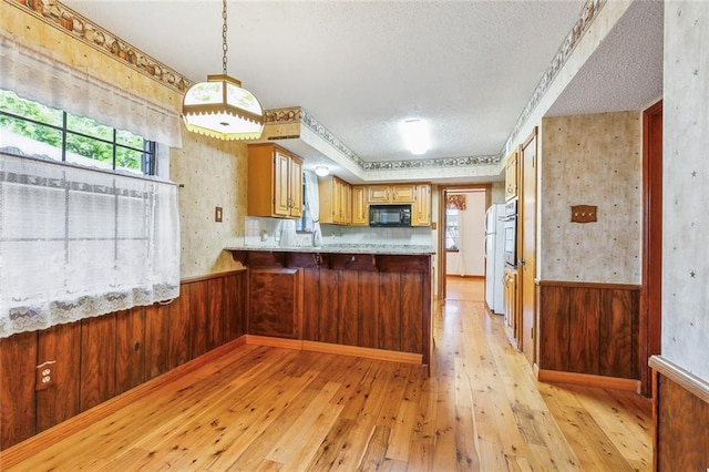 106 Somerset Rd, La Place, LA 70068 - kitchen with a textured ceiling, wallpapered walls, freestanding refrigerator, and black microwave