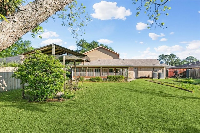 106 Somerset Rd, La Place, LA 70068 - back of property with central AC unit, fence, and a lawn