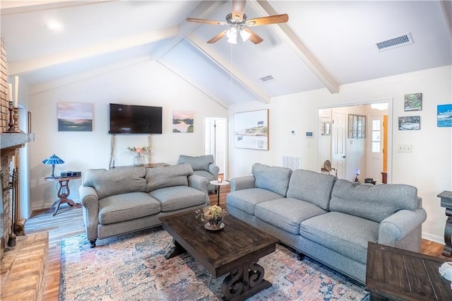 living area with baseboards, lofted ceiling with beams, light wood-style flooring, a ceiling fan, and visible vents