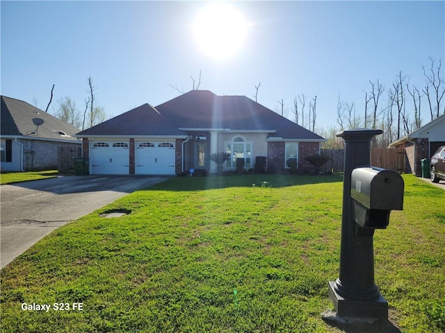 637 Foxwood Ln, La Place, LA 70068 - single story home featuring an attached garage, driveway, a front yard, and fence
