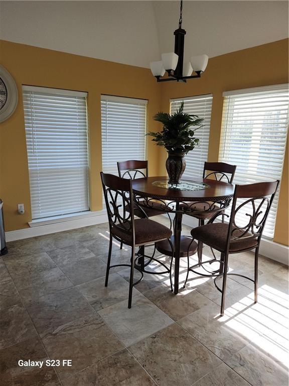 637 Foxwood Ln, La Place, LA 70068 - dining room featuring high vaulted ceiling, baseboards, and an inviting chandelier