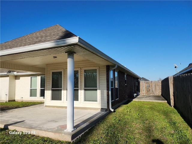 637 Foxwood Ln, La Place, LA 70068 - rear view of house with a patio, a shingled roof, a fenced backyard, and a yard