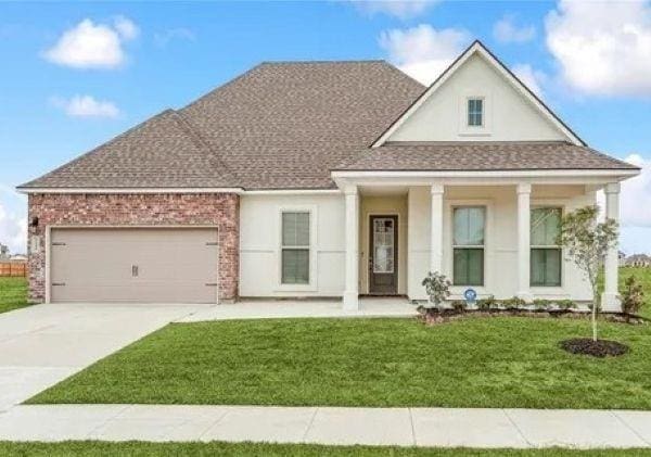 view of front of home with driveway, a shingled roof, a front lawn, brick siding, and a garage