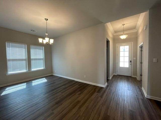 entrance foyer featuring dark wood-style floors, visible vents, an inviting chandelier, and baseboards