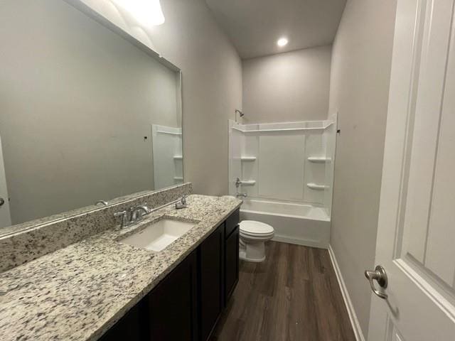 bathroom featuring wood finished floors, toilet, shower / bath combination, vanity, and baseboards