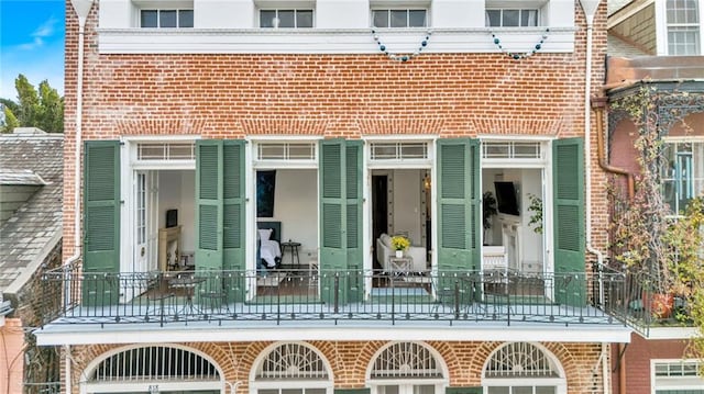 818 Bourbon St Unit 2A, New Orleans, LA 70116 - view of exterior entry with brick siding and a balcony