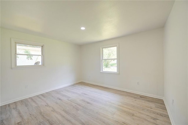 unfurnished room with baseboards, recessed lighting, and light wood-style floors