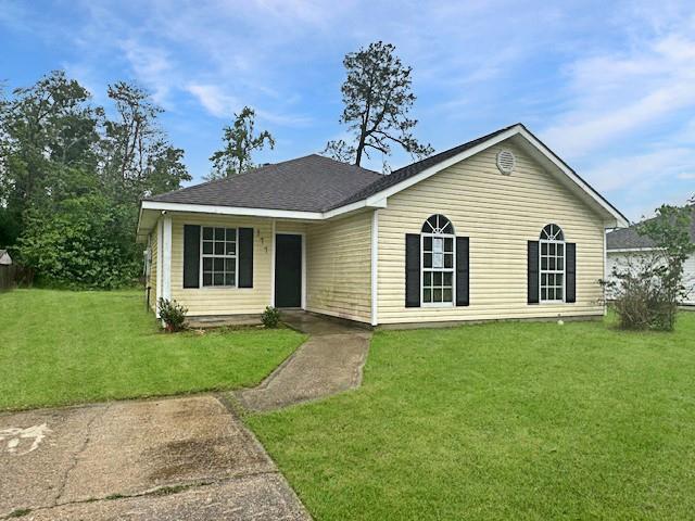 ranch-style home with a front yard and a shingled roof