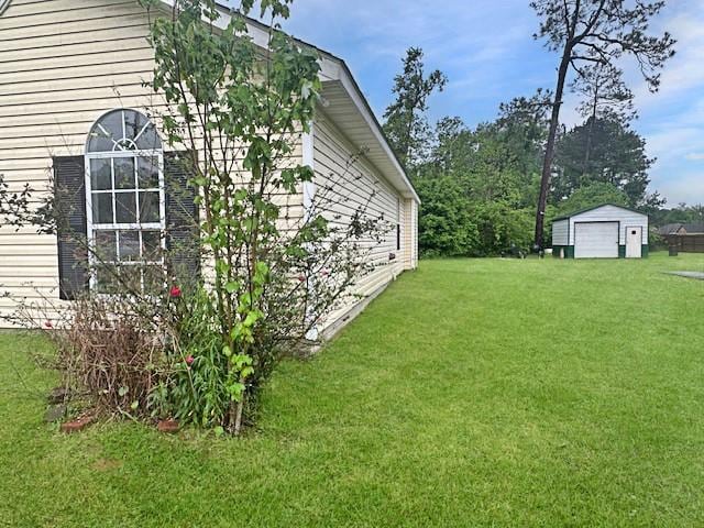 view of yard featuring a garage and an outbuilding