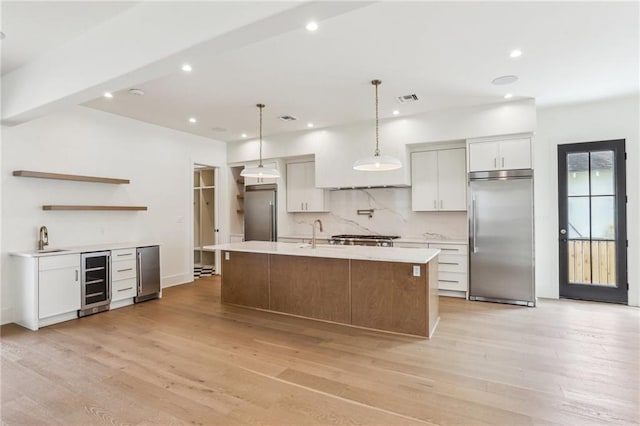 6371 Louis Xiv St, New Orleans, LA 70124 - kitchen with stainless steel built in refrigerator, beverage cooler, light countertops, tasteful backsplash, and light wood-style flooring