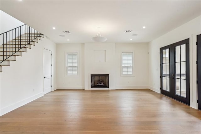 6371 Louis Xiv St, New Orleans, LA 70124 - unfurnished living room featuring light wood finished floors, a fireplace, recessed lighting, stairway, and french doors