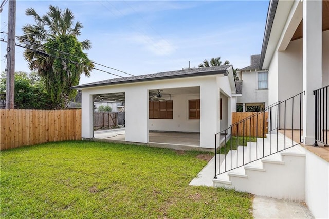 6371 Louis Xiv St, New Orleans, LA 70124 - back of property featuring a patio, stucco siding, a fenced backyard, ceiling fan, and a shingled roof