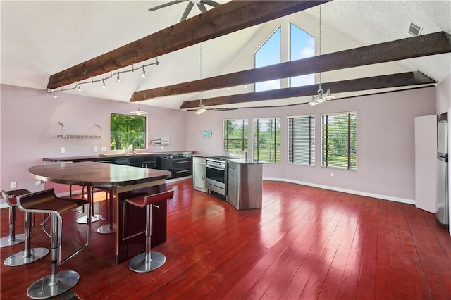 kitchen with visible vents, dark wood finished floors, stainless steel appliances, a sink, and ceiling fan