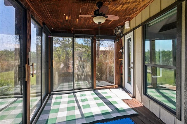 unfurnished sunroom with ceiling fan