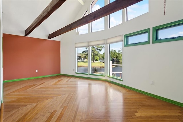 unfurnished living room featuring a water view, beam ceiling, baseboards, and high vaulted ceiling