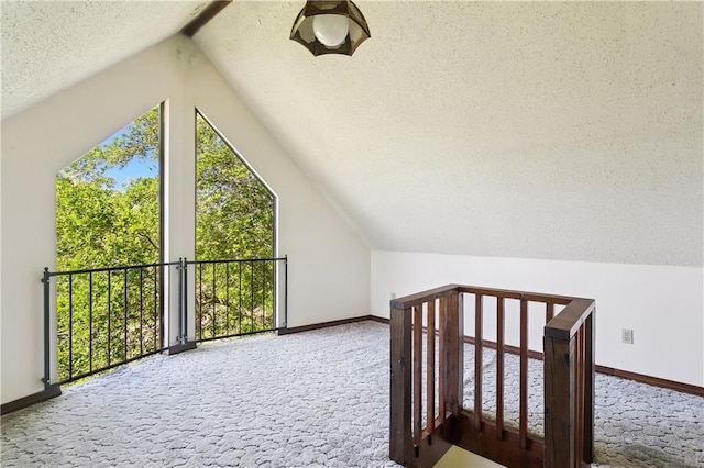 additional living space featuring baseboards, carpet flooring, and a textured ceiling