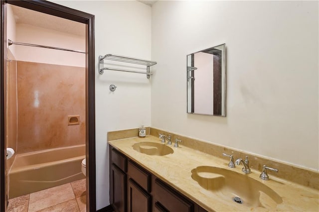 bathroom with toilet, double vanity, a sink, and tub / shower combination