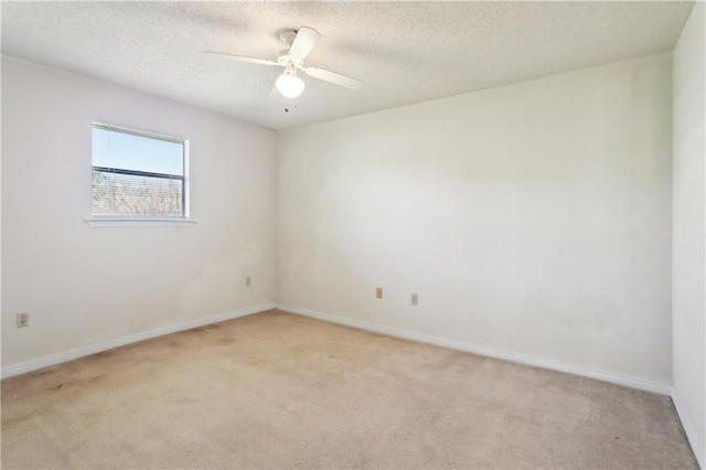 spare room with light carpet, baseboards, a textured ceiling, and ceiling fan