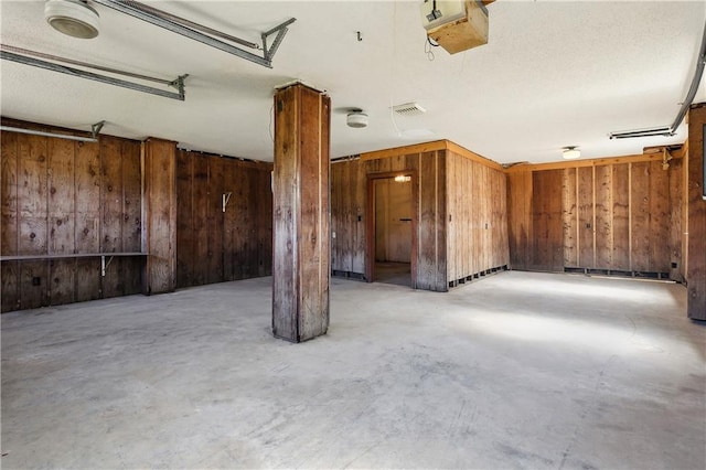 spare room with wooden walls and concrete flooring