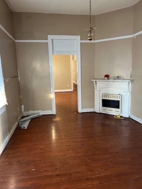 275755 Toulouse St, New Orleans, LA 70119 - unfurnished living room with baseboards, heating unit, and wood finished floors