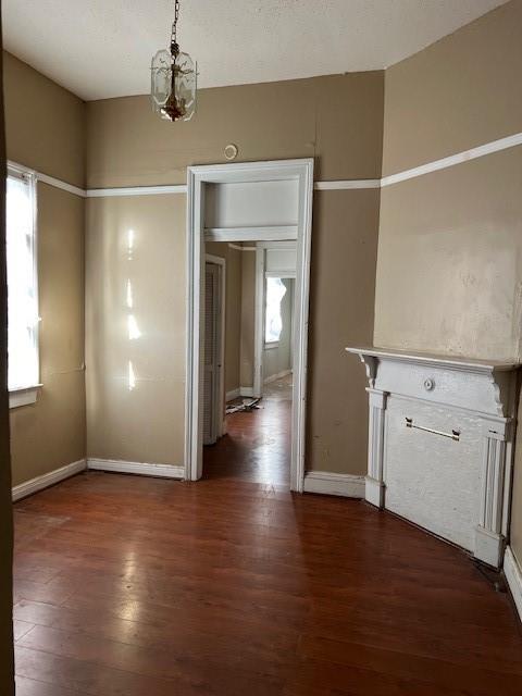 275755 Toulouse St, New Orleans, LA 70119 - unfurnished dining area featuring an inviting chandelier, baseboards, dark wood-style floors, and a wealth of natural light